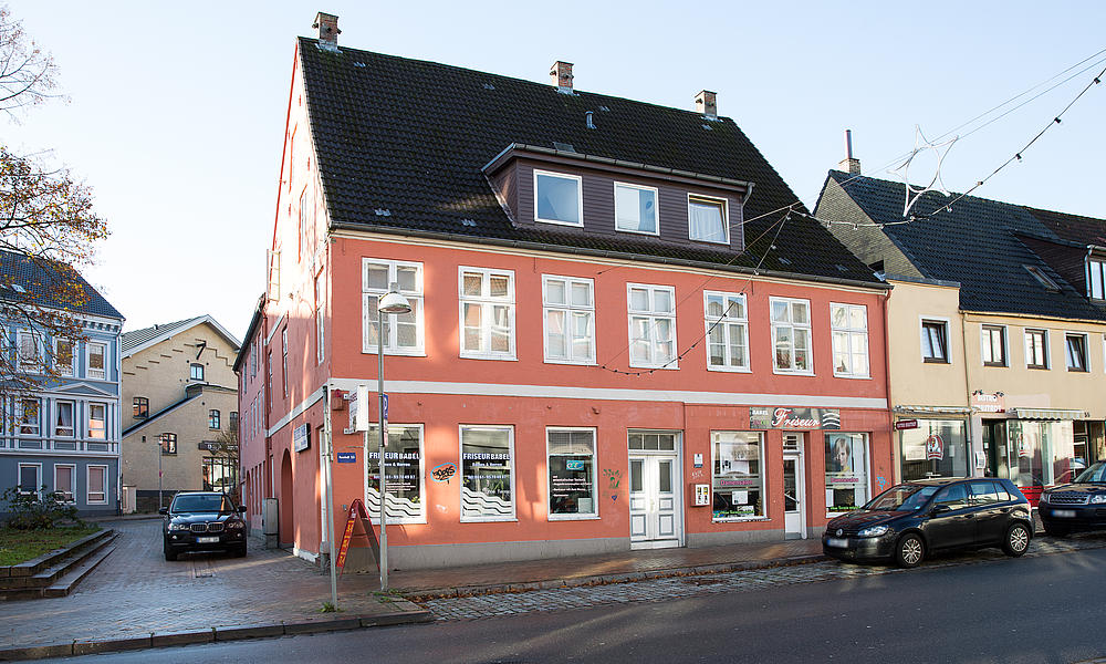 Ansicht von links auf das rote Mehrfamilienhaus in der Neustadt 53.
